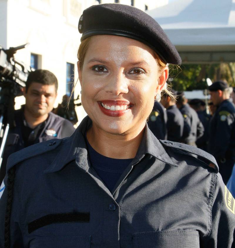 guarda mulher fardada sorrindo para a foto